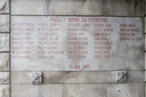 Spominska plošča na pokopališkem zidu v Križu
